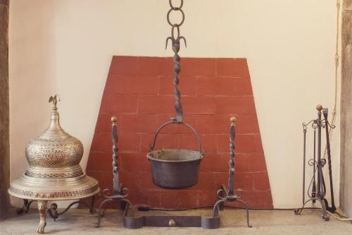 a metal bucket on a stand next to a brick wall at Hotel Centrale in Viterbo