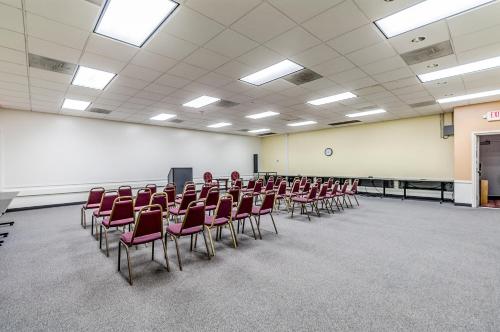 a conference room with red chairs and a podium at Motel 6-Dumfries, VA in Dumfries