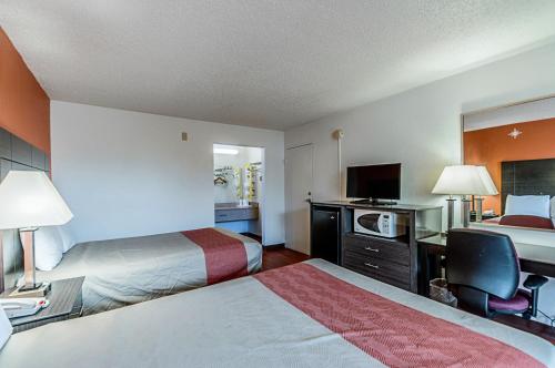 a hotel room with two beds and a desk at Motel 6-Dumfries, VA in Dumfries