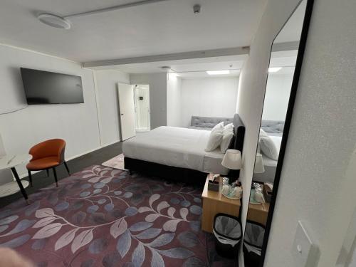 a hotel room with a bed and a mirror at Vienna Motel in Paihia
