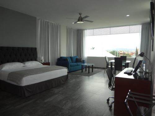 1 dormitorio con cama, silla azul y escritorio en Hotel Civic Express, en Poza Rica de Hidalgo