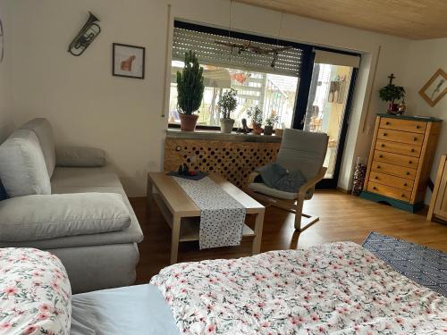 a living room with a bed and a couch and a table at Glücksmomente in Wolfegg