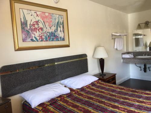 um quarto de hotel com uma cama e um lavatório em Sand Piper Motel - Los Angeles em Los Angeles