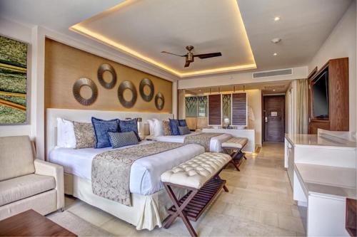 two beds in a room with a tub and a bathroom at Royalton Negril, An Autograph Collection All-Inclusive Resort in Negril