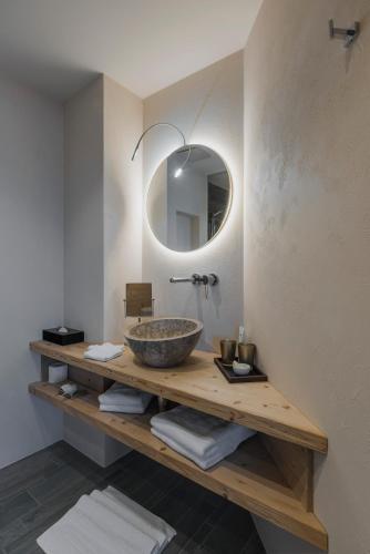 a bathroom with a counter with a sink and a mirror at Caschu Alp Boutique Design Hotel Stoos - adults only in Stoos