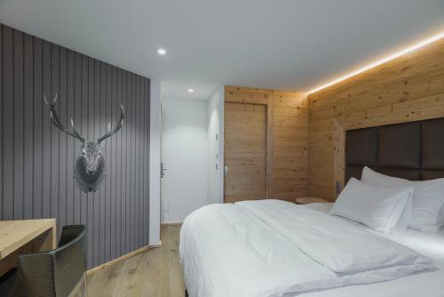 a bedroom with a bed with a deer head on the wall at Caschu Alp Boutique Design Hotel Stoos - adults only in Stoos