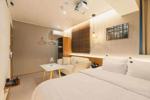 a hotel room with a bed and a chair at 부평 이상한호텔 in Pup'yŏng-yŏk