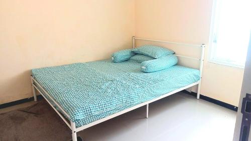 a bed with a pillow on it in a room at Locita Villa in Batu
