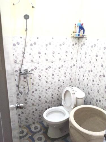 a bathroom with a shower with a toilet and a sink at Locita Villa in Batu