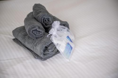 a pile of towels sitting on top of a bed at Hotel HIRAKU RYUKYU -STYLE- in Naha