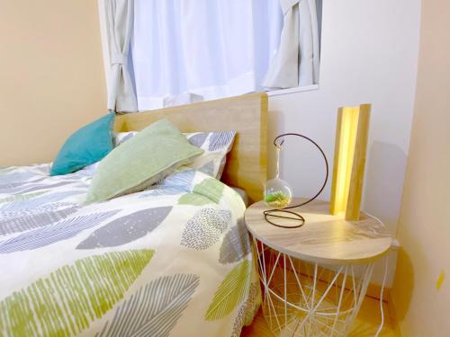 a bedroom with a bed with a table next to it at nestay villa tokyo otsuka in Tokyo