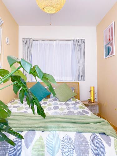 a bedroom with a bed with a plant at nestay villa tokyo otsuka in Tokyo