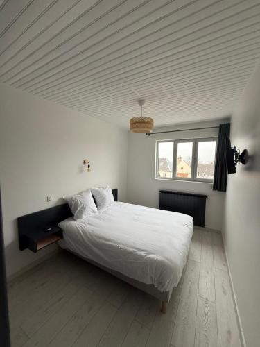a bedroom with a large white bed with a ceiling at Le Panoramique in Saint-Parize-le-Châtel