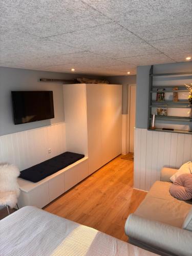 a bedroom with a bed and a flat screen tv at Glentevej idyl in Assens