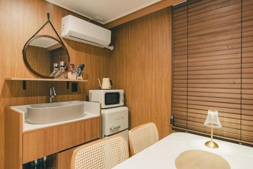 a kitchen with a table and a sink and a microwave at 부평 이상한호텔 in Pup'yŏng-yŏk