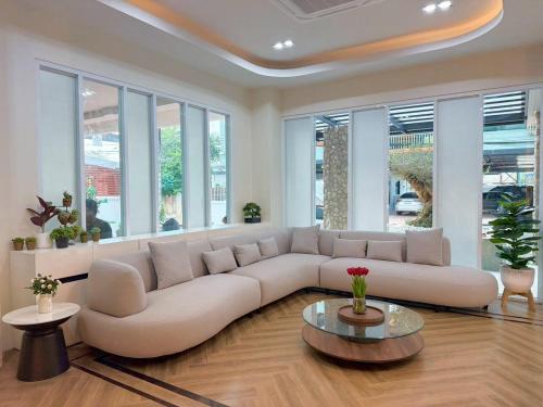 a living room with a white couch and a table at Indigo Hotel Hatyai 2 Khet 8 in Sathani Hat Yai