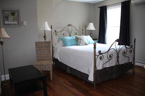 a bedroom with a bed with blue pillows and a window at Tandem Bike Inn in Belmar
