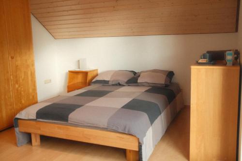 a bedroom with a bed with a striped comforter at Pension am Waldrand in Sinsheim