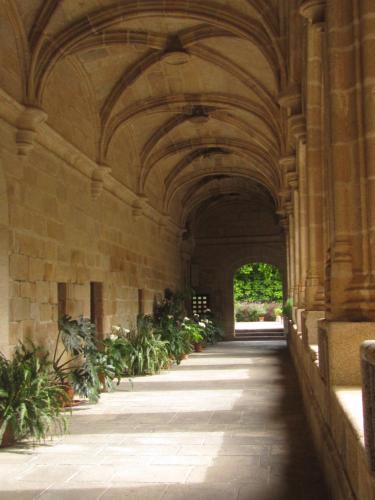 an arcade in a building with plants in it at Luz del Tajo in Alcántara