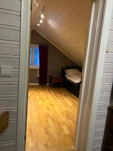 an attic room with a bed and a wooden floor at The house in Vika in Lødingen