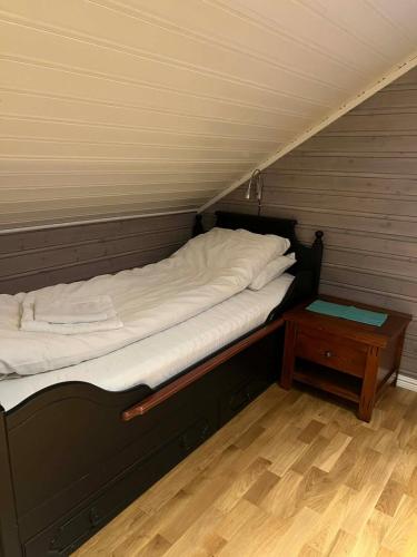 a small bed in a room with a table at The house in Vika in Lødingen