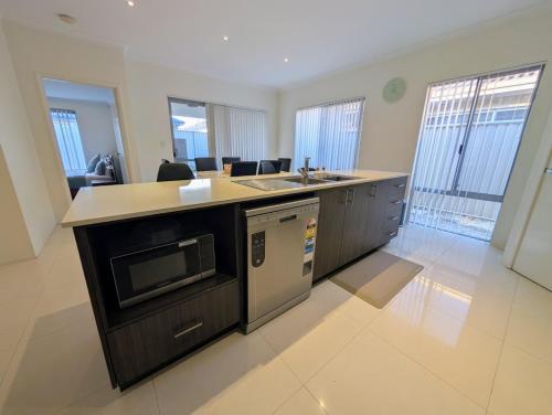 a kitchen with a sink and a microwave at Grand stay in Perth