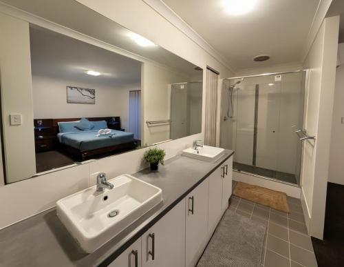 a bathroom with two sinks and a large mirror at Grand stay in Perth