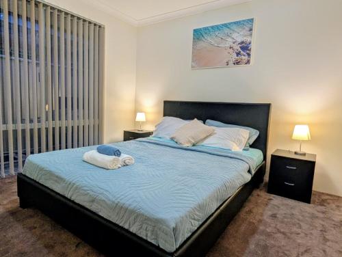 a bedroom with a bed with two towels on it at Grand stay in Perth
