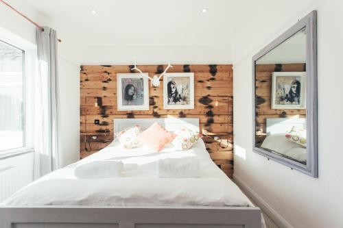 a bedroom with a white bed and a mirror at Storm in a tea cup in St Ives