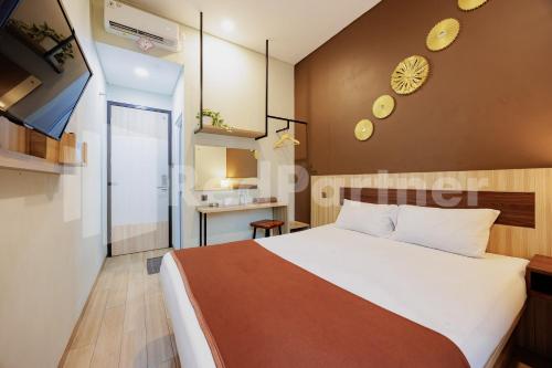 a bedroom with a large white bed in a room at Hotel Gandamanah Mitra RedDoorz in Bekasi