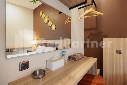 a mirror on the wall above a counter in a room at Hotel Gandamanah Mitra RedDoorz in Bekasi