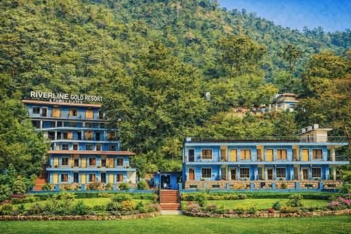 a building in front of a mountain at Riverline Gold Resort in Rishīkesh
