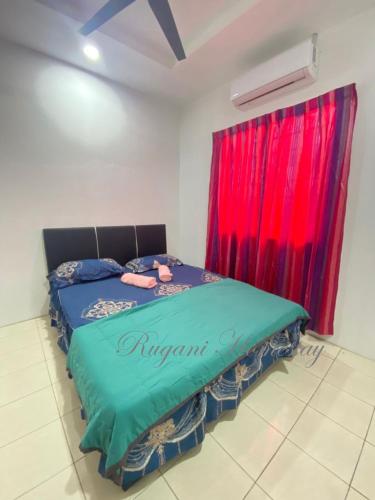 a bed in a room with a red curtain at Rugani Homestay in Papar
