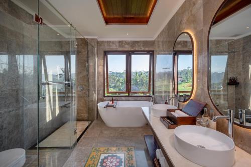 a bathroom with a tub and a sink and a shower at Emana Abian Taksu in Ubud