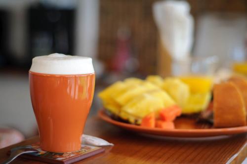 a glass of beer sitting on a table with a plate of food at 21 Palms in Las Galeras