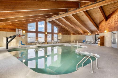 a large swimming pool in a building with wooden ceilings at AmericInn by Wyndham Aberdeen Event Center in Aberdeen