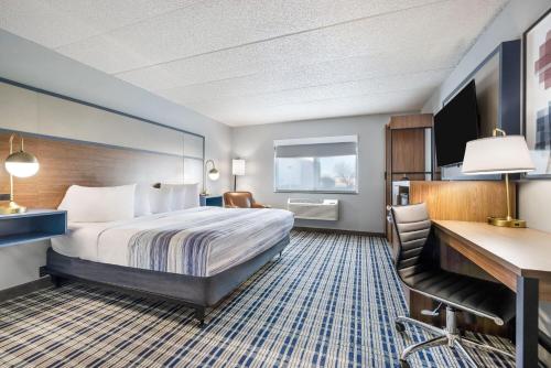 a hotel room with a bed and a desk at AmericInn by Wyndham Aberdeen Event Center in Aberdeen