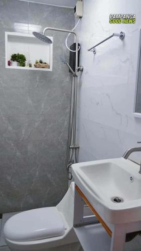 a bathroom with a toilet and a sink at Tatz Pool Villa in Anunas