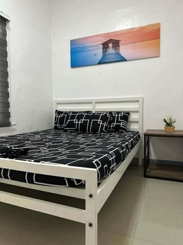 a bed in a room with a picture on the wall at Tatz Pool Villa in Anunas