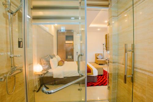 a bathroom with a shower and a bed in a room at Smile Hotel in Hanoi