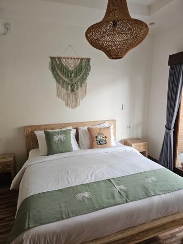 a bedroom with a bed with a green comforter at Villa Casa Delta Canggu in Canggu