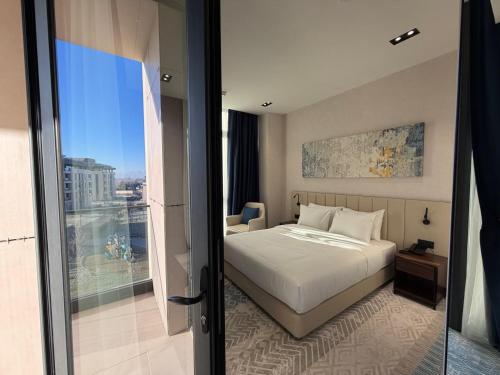 a hotel room with a bed and a balcony at Surxondaryo Hotel Tashkent in Teshabayguzar