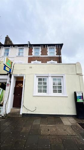 a white house with a door and a building at Dalston Luxe Studios, 10 minutes away from Liverpool Train Station in London