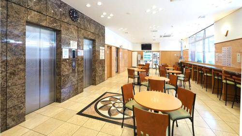 a restaurant with tables and chairs and a bar at Toyoko Inn Kumamoto-jyo Toricho Suji in Kumamoto