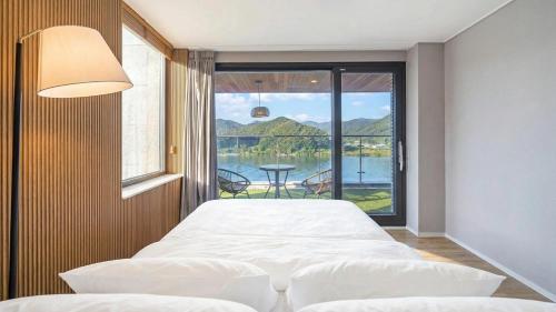 a bedroom with two beds and a view of the water at Gapyeong Laputa Resort in Gapyeong