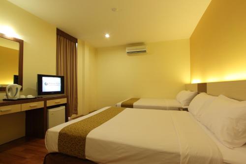 Habitación de hotel con cama y TV en Seasons View Hotel, en Kuantan