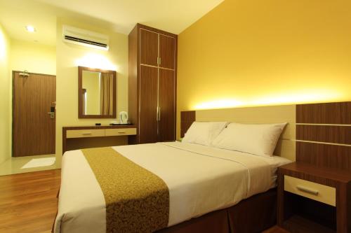 a bedroom with a large bed and a mirror at Seasons View Hotel in Kuantan