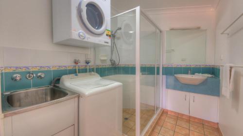 a small bathroom with a sink and a shower at Dolphin Waters in Tin Can Bay