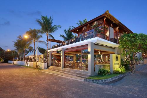 a building with a restaurant on the side of a street at Bali Niksoma Boutique Beach Resort in Legian