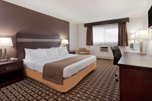 a hotel room with a bed and a desk at Super 8 by Wyndham Valemount in Valemount
